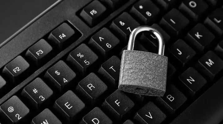 Un candado reposa sobre un teclado de computadora negro, simbolizando la ciberseguridad y la protección vital para prácticas seguras de email marketing.