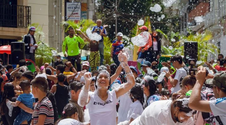 En medio de un cielo soleado, la multitud se deleita con la magia de la fiesta de la espuma, que encarna el espíritu animado de la industria de eventos en México. Las sonrisas abundan mientras la gente levanta las manos entre las burbujas de espuma que se arremolinan, encapsulando la alegría y la celebración en este vibrante festival.