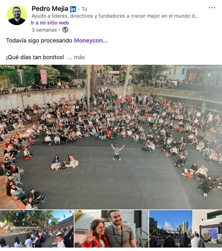 Un grupo grande de personas se sienta en círculos concéntricos en una calle al aire libre, algunas personas levantan los brazos y otras permanecen de pie cerca.